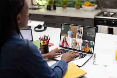 Çevrimiçi derste bilgisayar ekranında öğretmenlere ve öğrencilere bakan Afrikalı Amerikalı genç kız. Değiştirilmemiş, çocukluk, teknoloji, eğitim, öğrenci, e-öğrenme, video çağrısı ve ev kavramı.