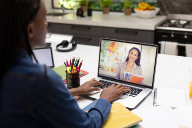 Laptop ekranında video üzerinden bayan öğretmeni dinleyen Afrikalı Amerikalı genç kız. Değiştirilmemiş, çocukluk, teknoloji, eğitim, öğrenci, e-öğrenim, öğrenim, öğretim ve ev.