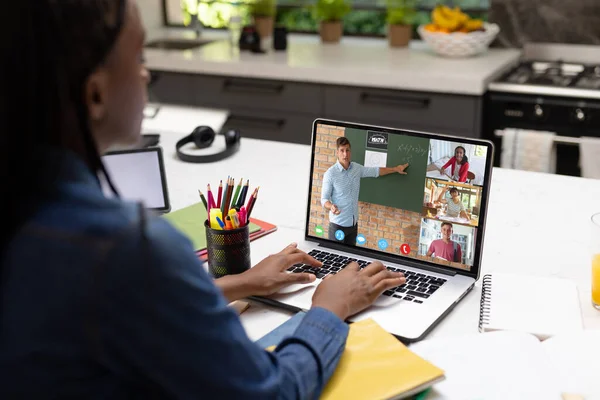 Afrika kökenli Amerikalı genç çocuk video görüşmesi sırasında öğretmen ve öğrencilerle birlikte laptop ekranına bakıyor. Değiştirilmemiş, çocukluk, teknoloji, eğitim, öğrenci, e-öğrenme, çevrimiçi ve ev kavramı.