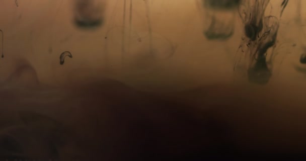 茶色の背景に対して水で混合する黒い水彩画インクのスローモーションビデオ 美しい抽象的な背景コンセプト — ストック動画
