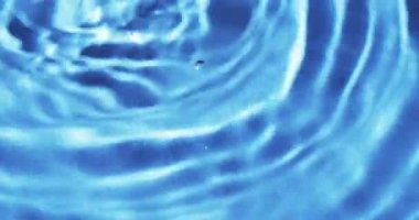 Mavi arkaplanda fotokopi alanı olan su damlalarının yakın çekim videosu. Sıvı, su ve hareket kavramı.