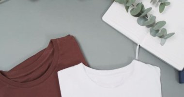 Gri arkaplanda fotokopi alanı olan düz tişörtlerin olduğu bir video. Moda, trendler ve giyim konsepti.