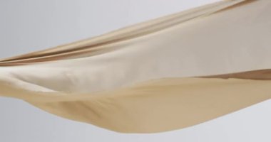 Beyaz arka planda fotokopi alanı ile uçan krem kumaş animasyonu. Kumaş, doku ve hareket kavramı dijital olarak oluşturuldu.