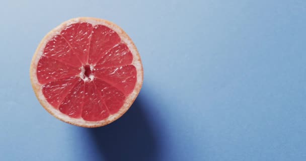 Video Von Aufgeschnittener Roter Grapefruit Mit Kopierfläche Auf Blauem Hintergrund — Stockvideo