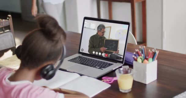 スローモーションで男性教師とのラップトップビデオ通話でクラスを持っている多様な女子高生 オンライン学習 — ストック動画