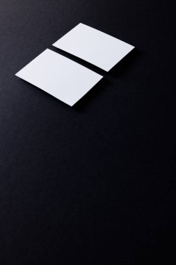 White business cards with copy space on black background. Business, business card, stationery and writing space digitally generated image.