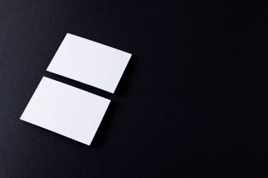 White business cards with copy space on black background. Business, business card, stationery and writing space digitally generated image.