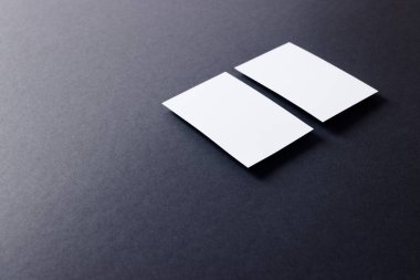 White business cards with copy space on black background. Business, business card, stationery and writing space digitally generated image.