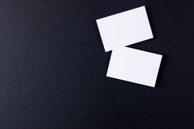 White business cards with copy space on black background. Business, business card, stationery and writing space digitally generated image.