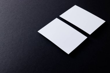 White business cards with copy space on black background. Business, business card, stationery and writing space digitally generated image.