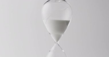 Kum saatinin kum dökümlü videosu, beyaz arka planda kopyalama alanı. Zaman ve zaman tutma kavramı.