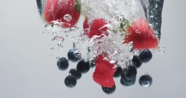 Böğürtlenlerin suya dökülme videosu ve beyaz arka planda kopya alanı. Meyve ve tazeliği kavramı.