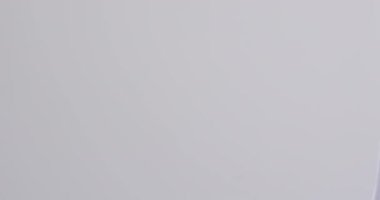 Askıda etiketi olan beyaz tişörtün videosu ve beyaz arka planda kopyalama alanı. Moda, trendler ve giyim konsepti.