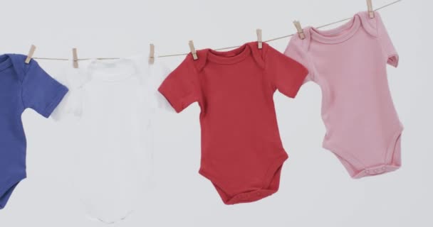 Vídeo Bebê Multicolorido Cresce Pendurado Pinos Linha Com Espaço Cópia — Vídeo de Stock