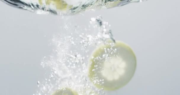 Wideo Plasterków Limonki Cytryny Wpadających Wody Miejscem Ksero Białym Tle — Wideo stockowe