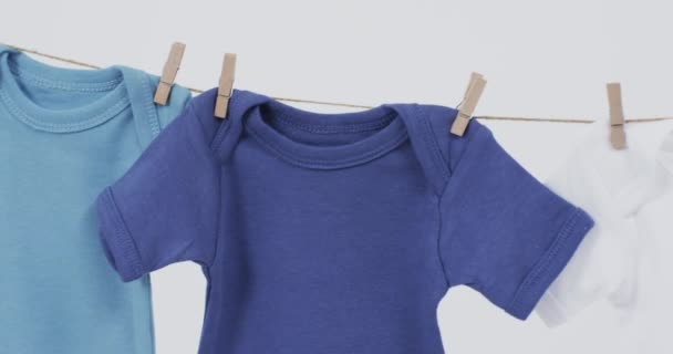 彩色婴儿的视频挂在铁钉上 白底上有复制空间 婴儿和儿童时尚 趋势和服装概念 — 图库视频影像