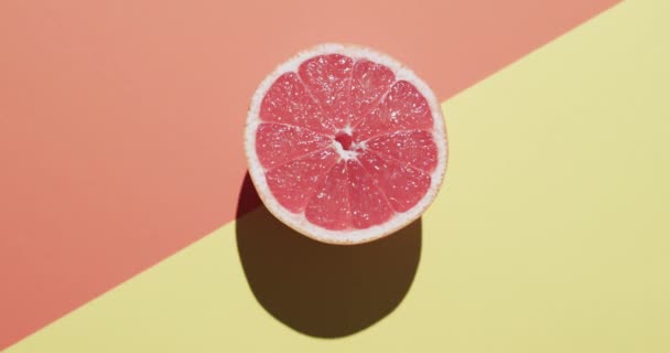 Video Von Aufgeschnittener Roter Grapefruit Mit Kopierraum Auf Orangefarbenem Und — Stockvideo