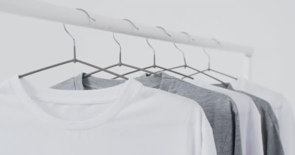 衣架上的白色和灰色T恤衫的视频和白色背景上的复制空间 潮流和服装概念 — 图库视频影像