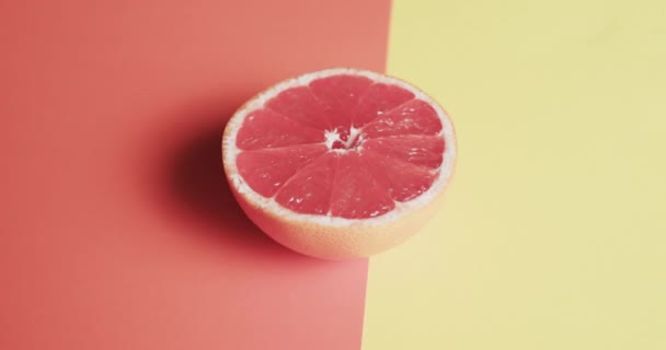 Video Von Aufgeschnittener Roter Grapefruit Mit Kopierraum Auf Orangefarbenem Und — Stockvideo