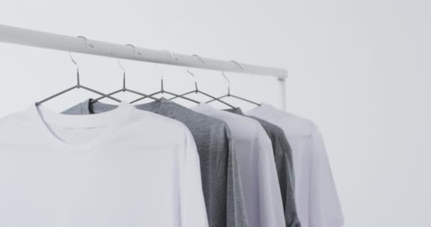 衣架上的白色和灰色T恤衫的视频和白色背景上的复制空间 潮流和服装概念 — 图库视频影像
