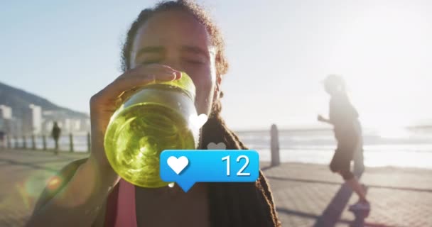 用数字动画的心脏图标在鸟类女运动员与大海的碰撞中喝水 数码合成 社交媒体 — 图库视频影像