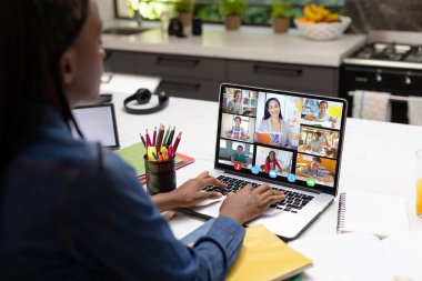 Afrika kökenli Amerikalı kadın öğretmen, kadın öğretmen ve çeşitli öğrencilerle video konferansı yapıyor. Uzak öğrenim çevrimiçi eğitim kavramı