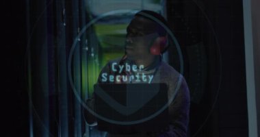 Sunucu odasında dizüstü bilgisayar kullanan Afro-Amerikan erkek mühendis üzerinde web küresi ikonu animasyonu. Siber güvenlik ve iş veri depolama teknolojisi kavramı