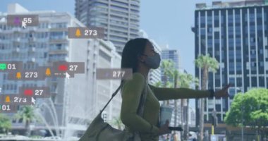 Sokakta taksi çağıran, yüz maskesi takan melez bir kadının sosyal medya simgelerinin canlandırılması. Sosyal medya ağı ve covid-19 salgın konsepti