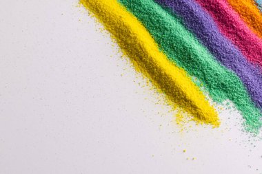 Çok renkli kum şeritlerini kapat ve beyaz arkaplanda kopyalama alanı oluştur. Kum, doku, hareket, şekil ve renk kavramı.