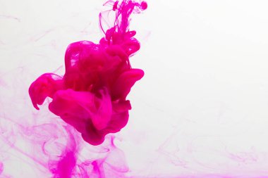 Sudaki pembe mürekkebi kapatın ve beyaz arkaplanda kopya alanı olsun. Mürekkep, sıvı, şekil ve renk kavramı.