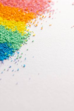 Gökkuşağı renkli kum şeritlerini kapatın ve beyaz arkaplanda kopyalayın. Kum, doku, hareket, şekil ve renk kavramı.