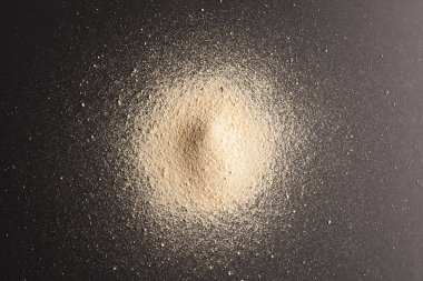 Kum yığınını kapat ve siyah arkaplana kopyala. Kum, doku, hareket, şekil ve renk kavramı.