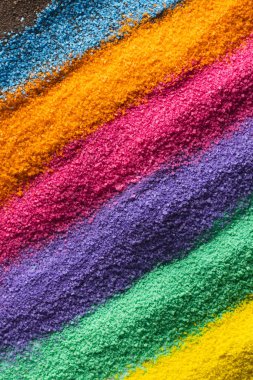 Gökkuşağı renkli kum ve fotokopi alanı arkaplanının şeritlerini kapatın. Kum, doku, hareket, şekil ve renk kavramı.