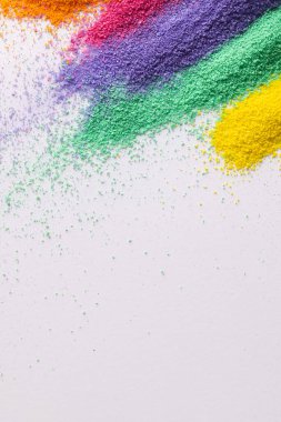 Çok renkli kum şeritlerini kapat ve beyaz arkaplanda kopyalama alanı oluştur. Kum, doku, hareket, şekil ve renk kavramı.