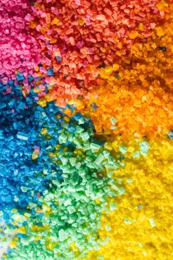 Arka planda çok renkli kum tanelerini kapatın. Kum, doku, hareket, şekil ve renk kavramı.