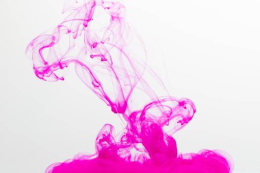 Sudaki pembe mürekkebi kapatın ve beyaz arkaplanda kopya alanı olsun. Mürekkep, sıvı, şekil ve renk kavramı.