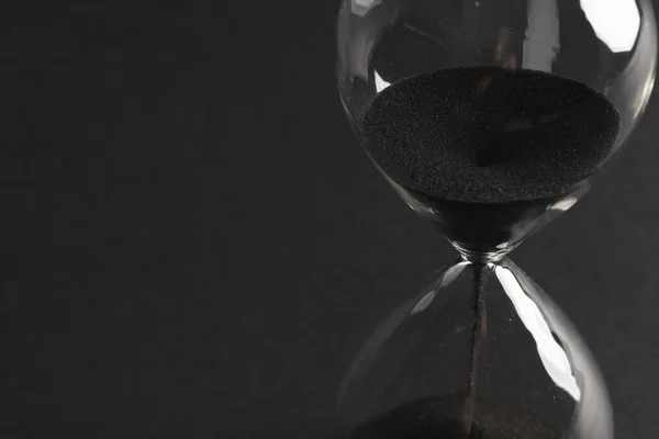 ブラックサンドで時計ガラスを閉じ 黒い背景にスペースをコピーします タイムキーピング カラーコンセプト — ストック写真