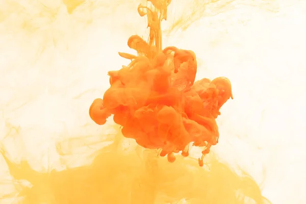 Close up of orange ink in water with copy space on white background. Ink, liquid, shape and colour concept.