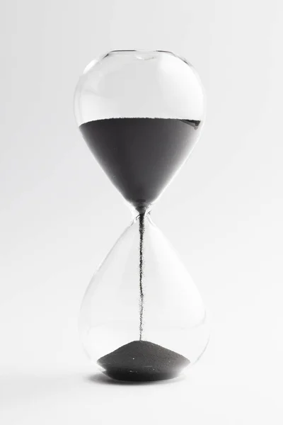 ブラックサンドで時計ガラスを閉じ 白い背景にスペースをコピーします タイムキーピング カラーコンセプト — ストック写真
