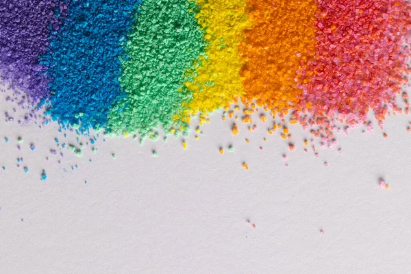 Gökkuşağı renkli kum şeritlerini kapatın ve beyaz arkaplanda kopyalayın. Kum, doku, hareket, şekil ve renk kavramı.