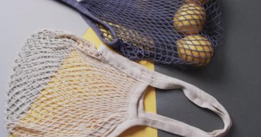 Limonlu mavi ve beyaz çantaların videosu ve gri ve sarı arka planda kopyalama alanı. Çanta, moda, alışveriş ve kumaş konsepti.