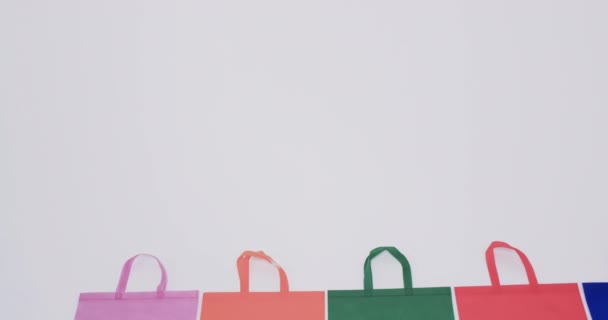 白い背景のコピースペースが付いている多着色されたキャンバスの袋のビデオ バッグ ショッピング ファッション ファブリックのコンセプト — ストック動画