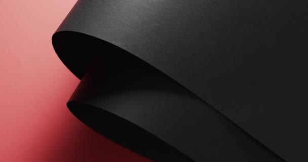 Close up of rolls of black paper and copy space on red background. Paper, stationery, shape and colour concept.