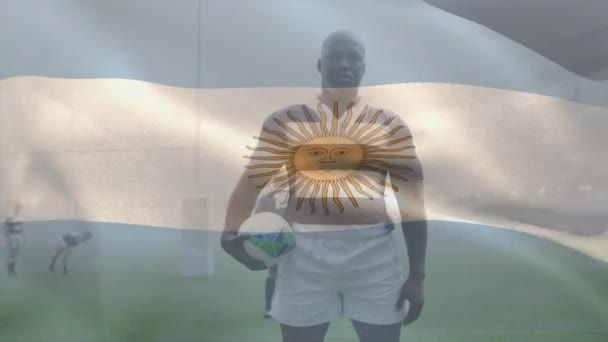 Animación Bandera Argentina Jugador Afroamericano Con Pelota Rugby Suelo Compuesto — Vídeo de stock