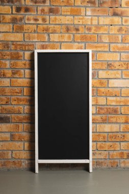 Beyaz çerçeveli siyah tabela ve tuğla duvar arkaplanındaki boşluğu kopyala. İmza, yazma alanı ve reklam kavramı.