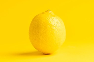 Limonu kapat ve sarı arkaplanda kopyala. Meyve, egzotik meyve, yiyecek, tazelik ve renk kavramı.