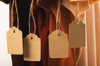 Etiketli dört tişört ve beyaz arka planda fotokopi alanı. Moda, kıyafetler, renk ve kumaş konsepti.