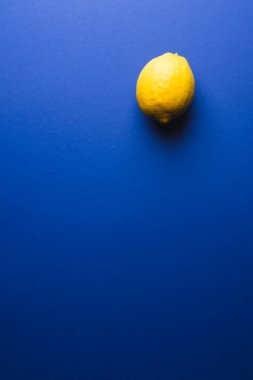 Mavi arka planda limon ve fotokopi alanını kapatın. Meyve, egzotik meyve, yiyecek, tazelik ve renk kavramı.