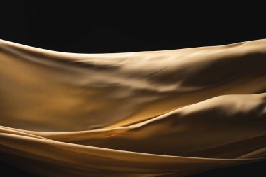 Siyah arkaplanda fotokopi alanı olan altın sarısı ipek kumaşı kapatın. Doku, kumaş, kumaş, renk ve malzeme.
