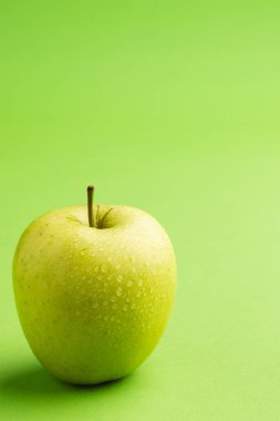 Yeşil elmayı kapat ve yeşil arkaplanda kopyala. Meyve, yemek, tazelik ve renk kavramı.